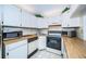 Bright kitchen features wood laminate countertops, white cabinets, and modern appliances at 2522 Pine Ridge S Way # A2, Palm Harbor, FL 34684