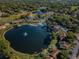 Aerial view of community with lake, pool, and numerous buildings at 2522 Pine Ridge S Way # A2, Palm Harbor, FL 34684