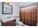 Bathroom with shower/tub combo, brown striped shower curtain and dark vanity at 2522 Pine Ridge S Way # A2, Palm Harbor, FL 34684