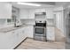 Modern kitchen with white shaker cabinets, granite countertops, and stainless steel appliances at 3611 Atlantis Dr, Holiday, FL 34691