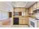 Kitchen features wood cabinets, white appliances, and wood flooring at 6316 Spoonbill Dr, New Port Richey, FL 34652