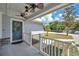 Front porch with white railings, blue door, and ceiling fan at 302 Leafwood Rd, Tarpon Springs, FL 34689