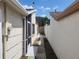 Side yard with concrete path and exterior door at 7832 Fox Den Row, Hudson, FL 34667