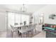 Elegant dining area with a large table, white chairs, and a modern chandelier at 13521 Stacey Dr, Hudson, FL 34667