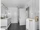 Elegant bathroom with double vanity, walk-in shower, and dark tile floors at 13521 Stacey Dr, Hudson, FL 34667