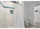 Clean bathroom with shower, toilet and white tile at 13521 Stacey Dr, Hudson, FL 34667