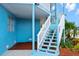Bright blue home exterior with white staircase leading to upper level at 13521 Stacey Dr, Hudson, FL 34667