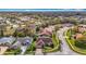 Neighborhood view featuring a home with a screened-in pool, green lawns, and winding streets at 8726 Latham Drive, Hudson, FL 34667