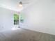 Bright bedroom features neutral carpeting, vaulted ceiling with fan, and a double window at 8726 Latham Drive, Hudson, FL 34667