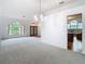 Open living room with a window view and a modern chandelier at 8726 Latham Drive, Hudson, FL 34667