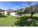 Landscaped backyard with lush lawn and mature tree at 4750 Carrington Ct, New Port Richey, FL 34655
