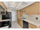 Kitchen features wood cabinets, black appliances, and tile floors at 4750 Carrington Ct, New Port Richey, FL 34655