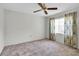 Bright bedroom with ceiling fan, window, and neutral carpeting at 4750 Carrington Ct, New Port Richey, FL 34655