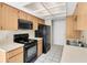 Kitchen boasts black appliances and wood cabinets at 4750 Carrington Ct, New Port Richey, FL 34655