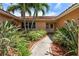 Inviting front entry with lush landscaping and a paved walkway leading to the house at 2044 Montana Ne Ave, St Petersburg, FL 33703