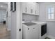 Bright laundry room with washer, dryer, and white cabinets at 3448 Triggerfish Dr, Hernando Beach, FL 34607