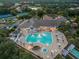 Aerial view of community pool, clubhouse, and tennis courts at dusk at 1183 Mystic Ct, Spring Hill, FL 34609