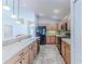 Open kitchen with light wood cabinets, black appliances, and island at 1183 Mystic Ct, Spring Hill, FL 34609