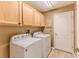Laundry room with wood cabinets, Whirlpool washer and dryer, and access door at 1183 Mystic Ct, Spring Hill, FL 34609