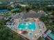 Aerial view of community pool, clubhouse, and tennis courts at dusk at 1183 Mystic Ct, Spring Hill, FL 34609