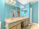 Double vanity bathroom with light blue walls and a large mirror at 1183 Mystic Ct, Spring Hill, FL 34609