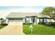 Single-story home with grey roof, attached garage, and well-maintained lawn at 4201 Avanti Cir, New Port Richey, FL 34655