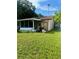 House exterior showcasing a screened porch and a cluttered backyard at 3310 68Th N Ave, St Petersburg, FL 33702