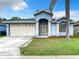Blue house with beige garage and palm tree at 7823 Floradora, New Port Richey, FL 34654