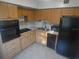 Kitchen with light wood cabinets and black appliances at 2370 Jamaican St # 56, Clearwater, FL 33763