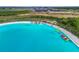 Aerial view of a community lagoon pool with kayaks and a swim area, perfect for Gathering fun at 31941 Blue Passing Loop, Wesley Chapel, FL 33545