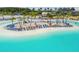 Aerial view of community pool with sandy island, lounge chairs and sunbathers in a tropical setting at 31941 Blue Passing Loop, Wesley Chapel, FL 33545