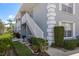 Ground floor entrance with landscaping and stairway to the second story of the building at 7712 Hillside Ct # 202, Hudson, FL 34667