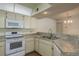 Updated kitchen features white appliances, countertops and ample cabinet space at 7712 Hillside Ct # 202, Hudson, FL 34667