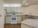 Bright kitchen features white appliances, cabinets, and countertop space at 7712 Hillside Ct # 202, Hudson, FL 34667