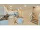 Open concept kitchen with island and stairs to upper level at 31941 Blue Passing Loop, Wesley Chapel, FL 33545