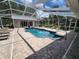 Inviting screened pool area with paved patio and lounge chairs at 11033 Baywind Ct, Weeki Wachee, FL 34613