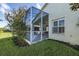 Screened porch with patio furniture and lush landscaping at 1633 Arbor Knoll Loop, Trinity, FL 34655