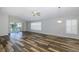 Open living room with high ceilings, wood-look floors, and plantation shutters at 1633 Arbor Knoll Loop, Trinity, FL 34655