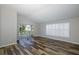 Living room with wood-look floors and sliding glass doors leading to a patio at 1633 Arbor Knoll Loop, Trinity, FL 34655