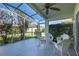 Spacious screened patio with ceiling fan and view of backyard at 1633 Arbor Knoll Loop, Trinity, FL 34655