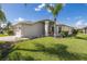 Tan house with garage and palm trees in the front yard at 1633 Arbor Knoll Loop, Trinity, FL 34655