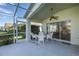 Relaxing screened patio furnished with white wicker chairs at 1633 Arbor Knoll Loop, Trinity, FL 34655