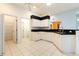 Bright kitchen with white cabinets, black countertops, and tile floors at 12200 Putter Green Ct, New Port Richey, FL 34654