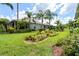 Landscaped backyard with lush greenery and palm trees at 12200 Putter Green Ct, New Port Richey, FL 34654