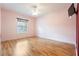 Spacious bedroom with wood-look floors, ceiling fan, and window at 12200 Putter Green Ct, New Port Richey, FL 34654