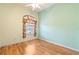 Bedroom with light walls, wood-look floors, and a large window at 12200 Putter Green Ct, New Port Richey, FL 34654