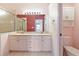 Bathroom features dual sinks, a shower, and white cabinets at 12200 Putter Green Ct, New Port Richey, FL 34654