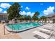 Refreshing community pool with lounge chairs and patio tables at 7712 Hillside Ct # 202, Hudson, FL 34667