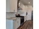 A modern kitchen with stainless steel appliances, white cabinets, granite countertops, and a gas range at 19492 Fort King Run, Brooksville, FL 34601