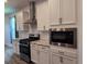 Modern kitchen featuring stainless steel appliances, white cabinets, subway tile backsplash, and granite countertops at 19492 Fort King Run, Brooksville, FL 34601